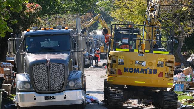 Workers remove damaged goods in flood-hit areas. Picture: Luis Ascui