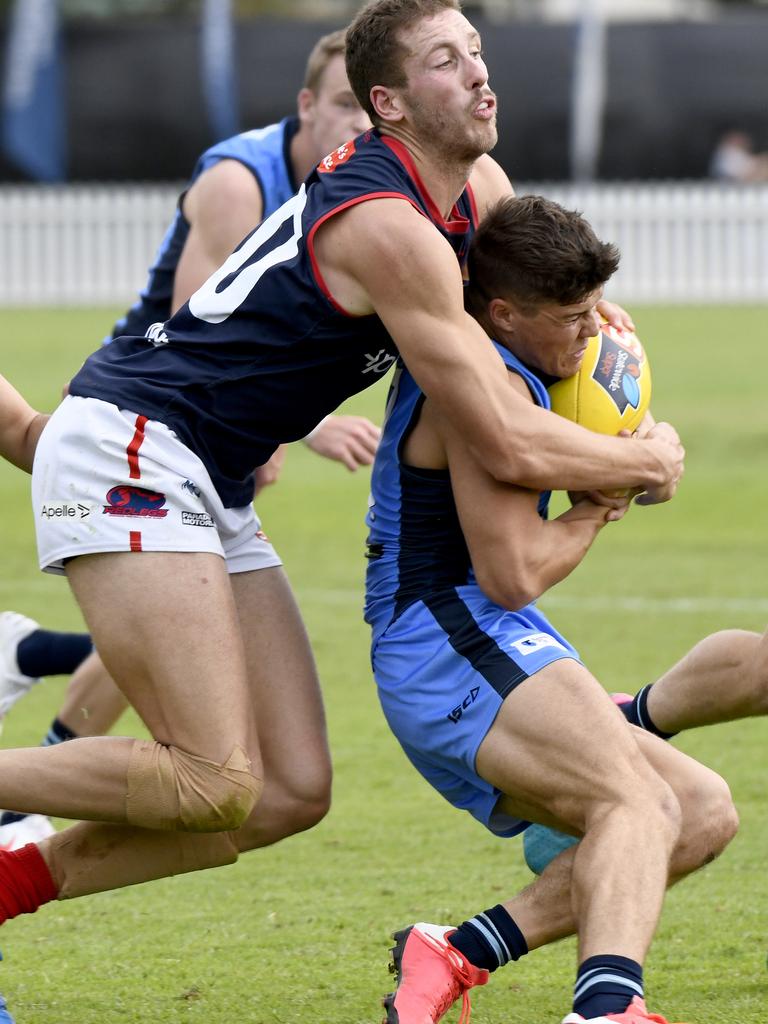 Sturt’s Tom Lewis tries to break a strong tackle from Norwood ruckman Michael Knoll. Picture: Naomi Jellicoe