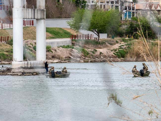 A migrant attempting to cross the Rio Grande is intercepted by Texas National Guard personnel. Picture: Sergio Flores