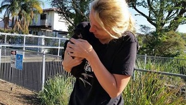 Catherine Kelaher comforts one of the chickens, whom she says is stressed.