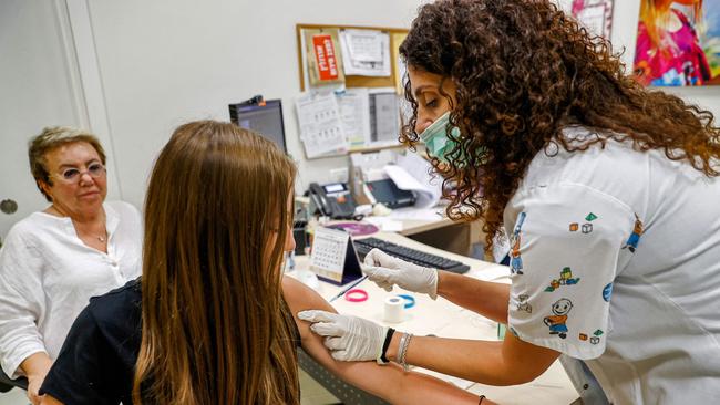 A teenage girl receives a dose of the Pfizer/BioNTech Covid-19 vaccine at the Clalit Healthcare Services in the Israeli city of Holon. Picture: AFP