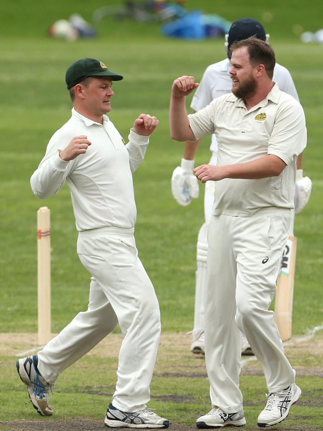 Parkville District bowler Andrew Green (right) celebrates after removing Sam Chapman.