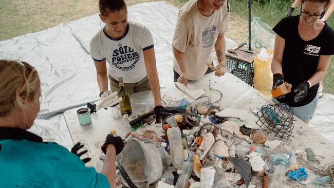 Volunteers work alongside the Ocean Crusaders team to clear rubbish from the Burnett River.