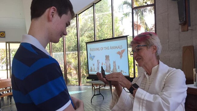 Alex Kous takes Brutus the croc to be blessed at the Christ Church Cathedral.