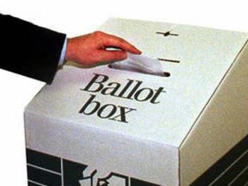 Undated : Generic hand dropping vote into a Ballot box - voting elections