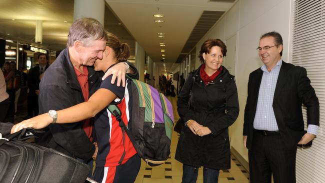 Coach Jim Joyce gives Barty a hug at the airport as mum Josie and dad Robert look on.