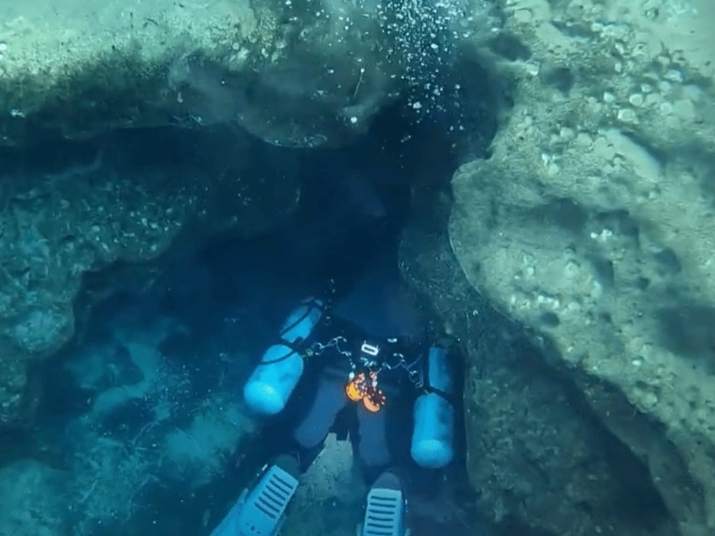 A stock image of a diver with oxygen mask seen deep inside the underwater caves. Picture: YouTube/Diver Doug’s Adventures