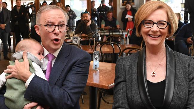 Anthony Albanese holdsle baby Charlie as he shares a coffee with former Prime Minister Julia Gillard during the 2022 federal election campaign in Adelaide.