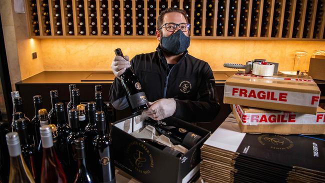 Tenafeate Creek Wines owner Michael Costa packs wine bottles after being inundated with orders from the public trying to support their small business, which became one of the tier one exposure sites. Picture: Tom Huntley