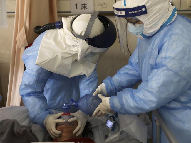 Medical workers pump oxygen into a new coronavirus patient at a hospital in Wuhan.