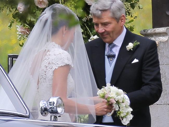 Michael Middleton helps his daughter out of the vintage car before entering the church. Picture: Flynetpictures.co.uk/IMP Features