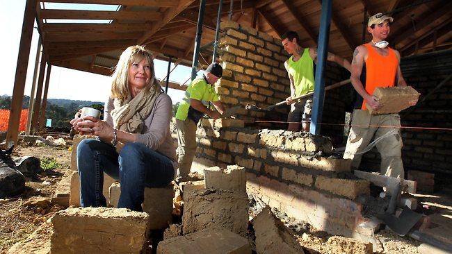 Julie McKellar watches her mud brick home being built in Eltham