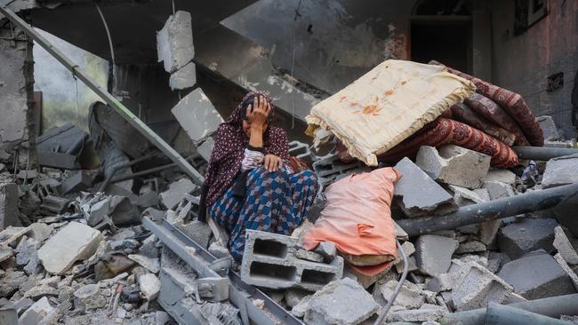 TOPSHOT - A woman cries while sitting on the rubble of her house, destroyed in an Israeli strike, in the Nuseirat refugee camp in central Gaza Strip on March 18, 2025. Israel on March 18 unleashed its most intense strikes on the Gaza Strip since a January ceasefire, with rescuers reporting 220 people killed, and Hamas accusing Benjamin Netanyahu of deciding to "resume war" after a deadlock on extending the truce. (Photo by Eyad BABA / AFP)