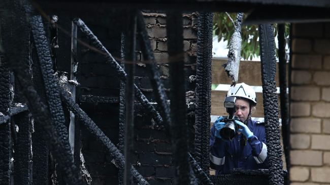 Investigators picking through the rubble. Picture: David Crosling