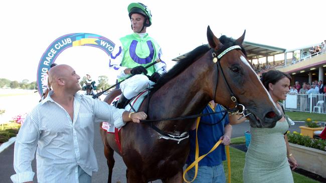 Racehorse Snitzel ridden by jockey Glen Boss is led back to scale by owner Damion Flower.