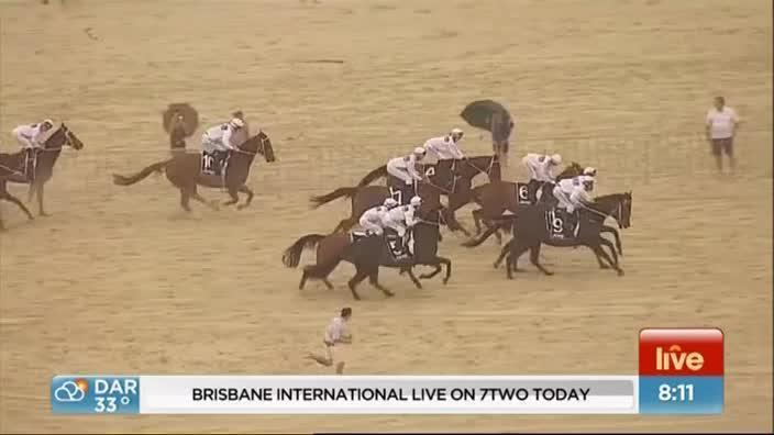 Horses race along Surfers Paradise Beach ahead of the Magic Millions