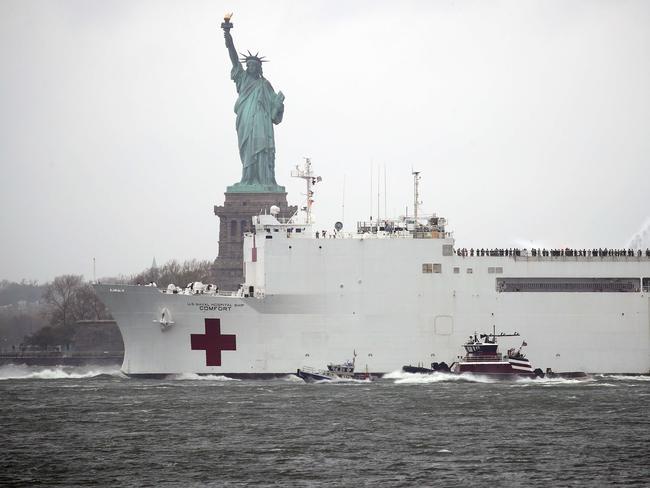 The USNS Comfort hospital ship exits the harbour in front of the Statue of Liberty as it heads back to Naval Station Norfolk in Virginia after being stationed in New York City. Picture: Getty Images/AFP