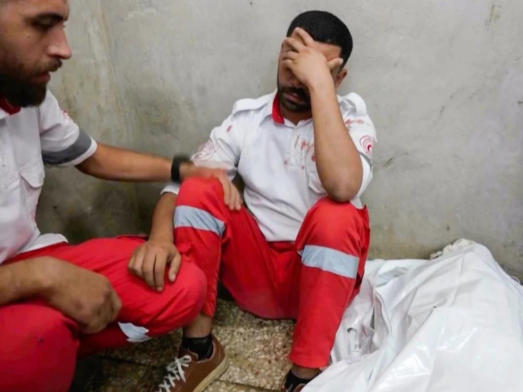 Abed Bardini held prayers for his mother before taking her body to an ambulance to be transported for a burial Credit: Abed Al Kareem Hana/AP