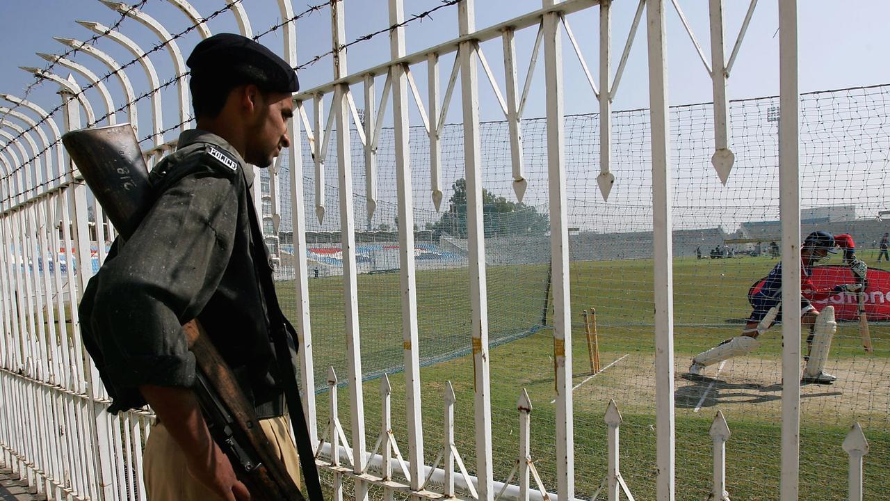 A security guard in Pakistan watches England captain Michael Vaughan at training in 2005.