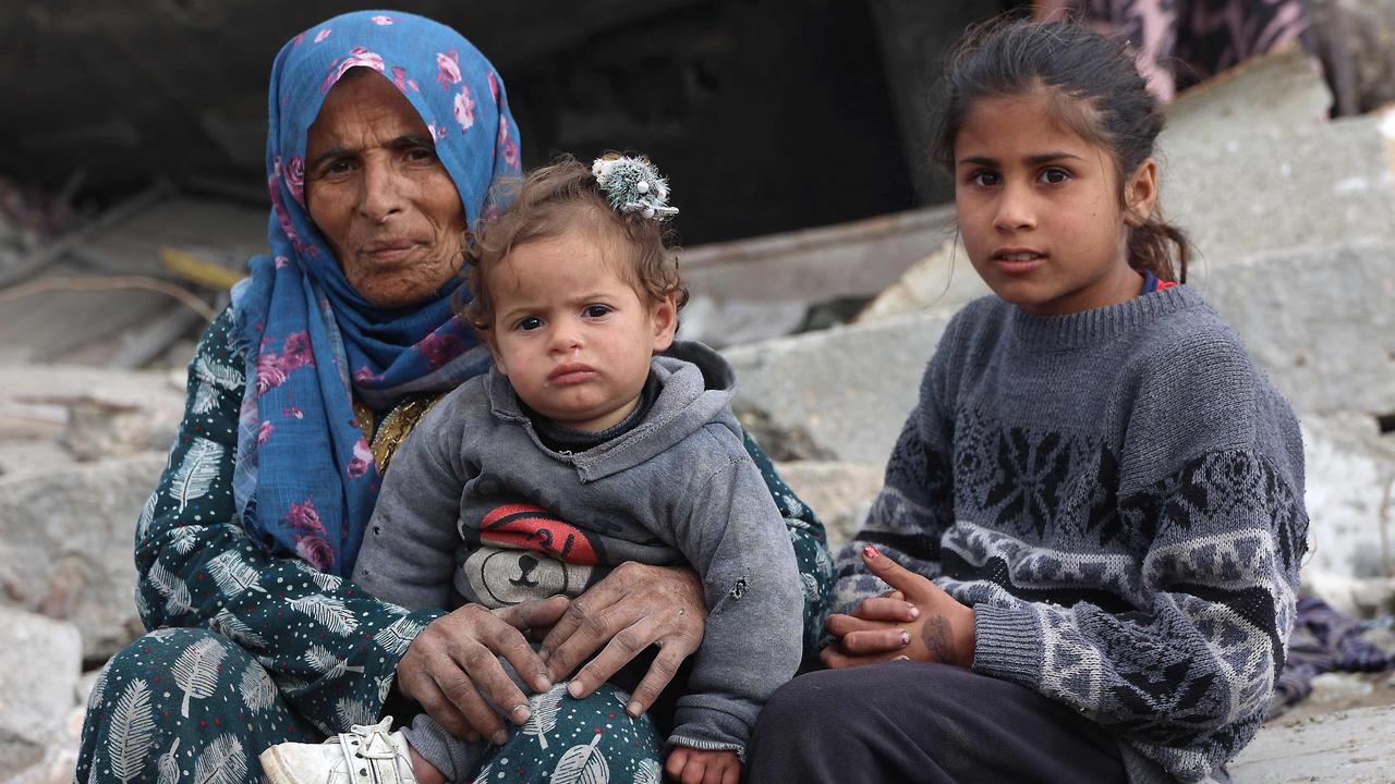 A Palestinian woman and children sit amid the rubble of destroyed buildings in Jabalia in the northern Gaza Strip. Picture: Omar Al-Qattaa / AFP