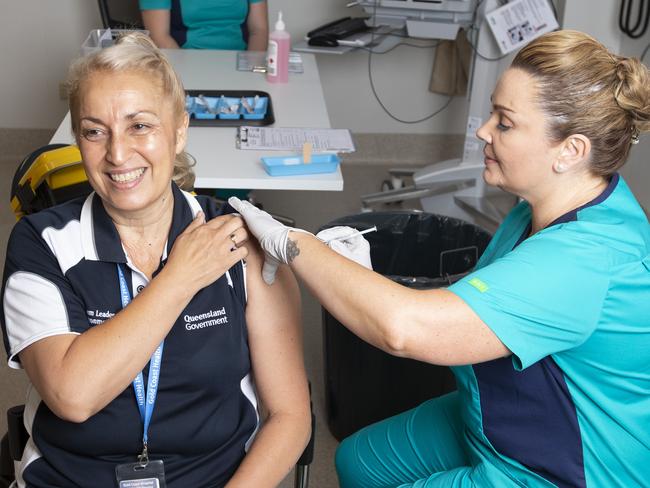 SOUTHPORT, AUSTRALIA - FEBRUARY 22:  A frontline worker receives the COVID-19 vaccine from clinical nurse consultant Kellie Kenway at Gold Coast University Hospital on February 22, 2021 in Southport, Australia. The first phase of the vaccination program includes up to 1.4 million doses of the Pfizer vaccine for frontline healthcare workers, quarantine personnel and aged care centre residents and employees. (Photo by Nigel Hallett-Pool/Getty Images)