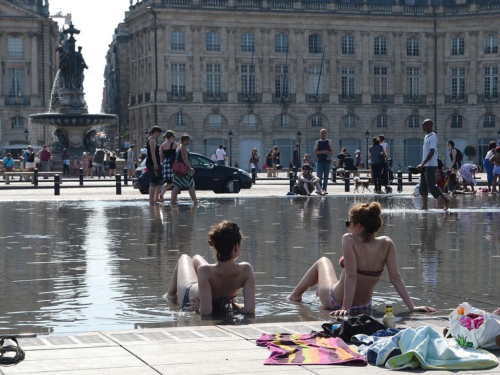 Young women in swimsuit lie on the water mirror in Bordeaux, on July 1, 2015, as a blistering heatwave sweeps through Europe with temperatures pushing 40 degrees Celsius. Picture: AFP