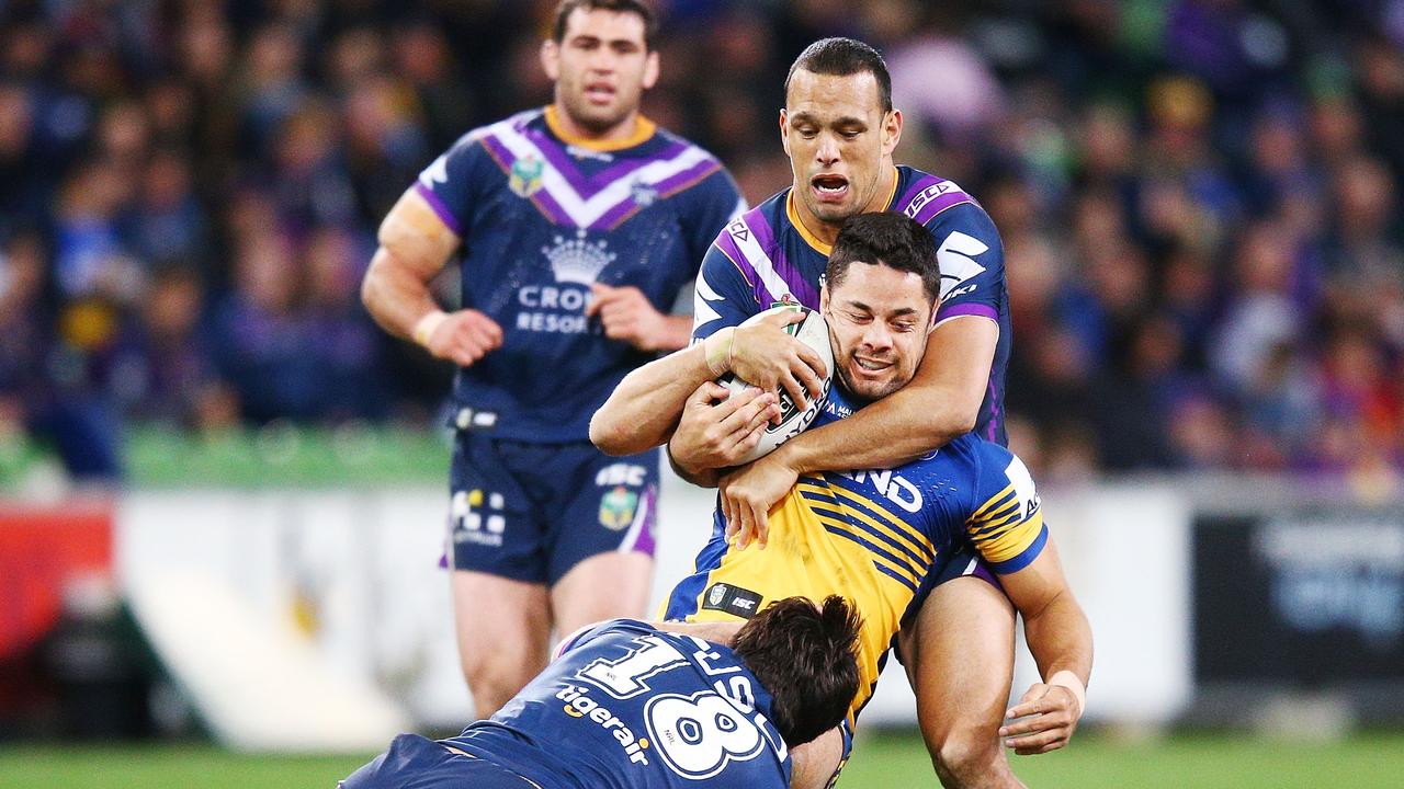 Brandon Smith of the Storm (L) and Will Chambers of the Storm tackle Jarryd Hayne of the Eels.