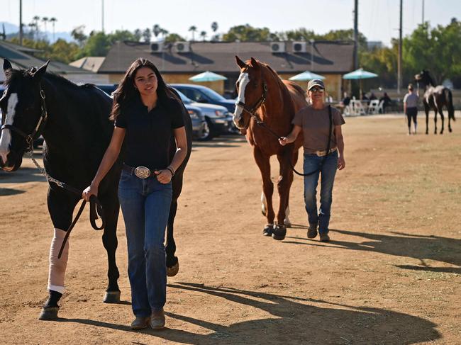 People walk their horses after they were evacuated from the Eaton fire, to the Los Angeles Equestrian Center in Burbank, California. Picture: Agustin Paullier/AFP