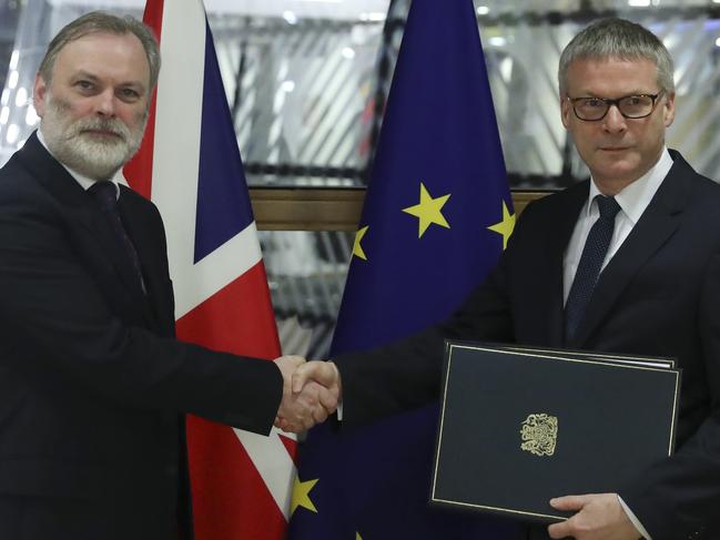 Sir Tim Barrow, UK Permanent Representative to the EU, left, delivers the Instruments of Ratification to European Council Secretary General Jeppe Tranholm-Mikkelsen, at the Europa Building in Brussels. Picture: AP