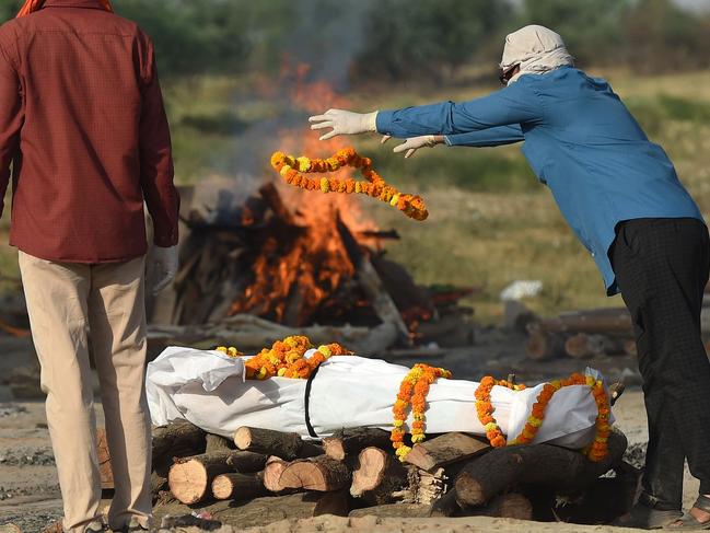 Relatives perform the last rites before the cremation of their loved one who died due to the Covid-19 coronavirus at a cremation ground in Allahabad.