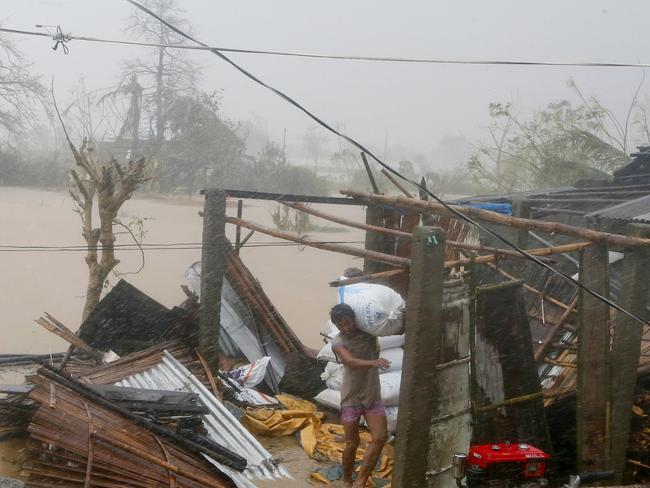 A resident carries a sack of rice after Super Typhoon Haima destroyed his home and caused flooding at Vigan township. Picture: AP
