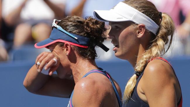 Caroline Wozniacki, right, of Denmark, looks on as Samantha Stosur, of Australia, wipes her face after their first round encounter. Photo: AP