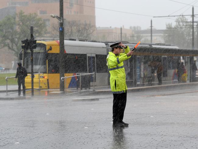 A police officer guiding peak-hour traffic in belting rain on Wednesday. Picture Greg Higgs