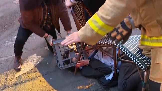 Members of the public pin down the attacker with a milk crate and chairs. Picture: Seven News