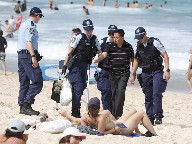 Police escort Kamal Arora off Bronte Beach on Australia Day. Picture: NewsWire / Damian Shaw