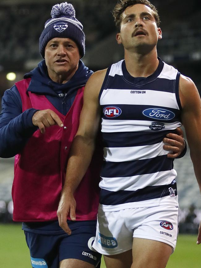 Luke Dahlhaus of the Cats leaves the field injured with Dr Geoff Allen. (AAP Image/Dylan Burns)