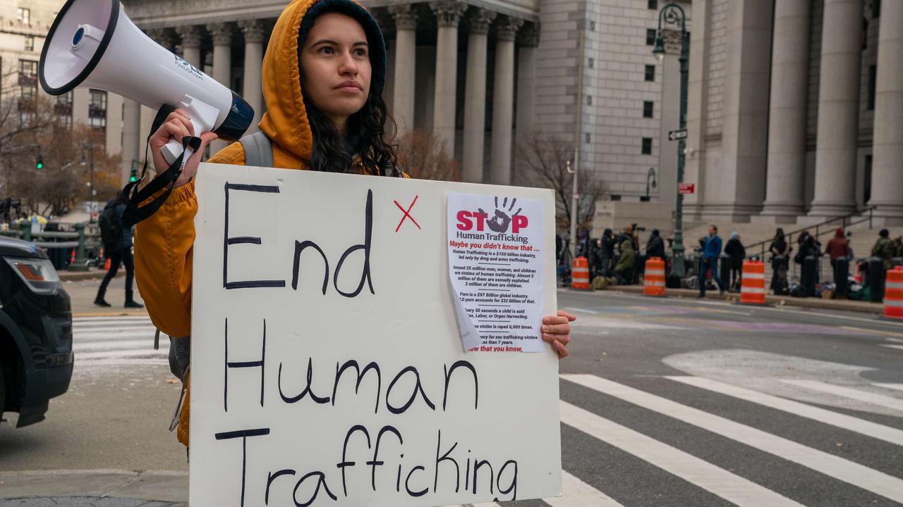 People gather to protest human trafficking at the Thurgood Marshall United States Courthouse where the trial of Ghislaine Maxwell is being held.