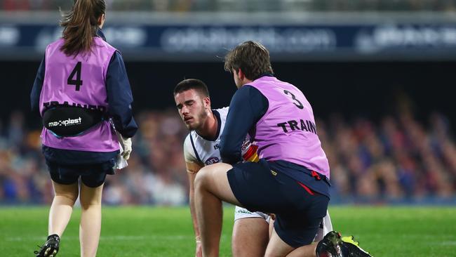 Lachlan Murphy of the Crows is helped by trainers after a head knock. Picture: Getty Images