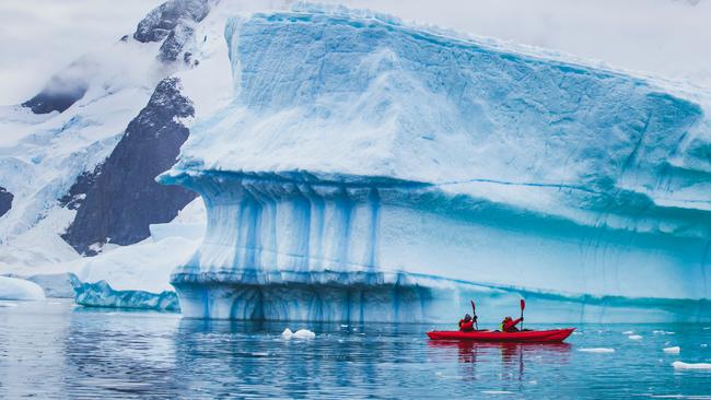 People paddling on kayak near iceberg in Antarctica. Picture: iStock.