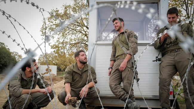 Tom, a tank commander with the 188th Brigade, left, with his unit and Bashar, a Syrian puppy. Picture: Michael Giladi/The Times