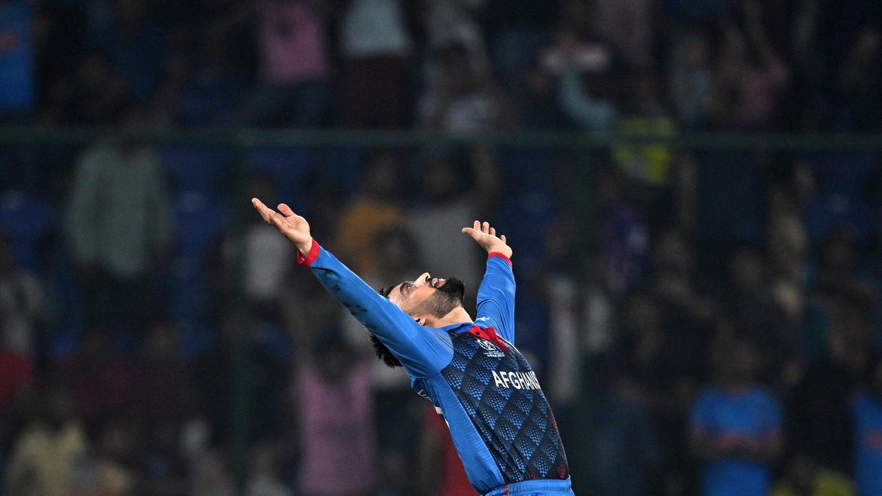 Afghanistan's Rashid Khan celebrates after taking the wicket of England's Mark Wood. (Photo by Money SHARMA / AFP)