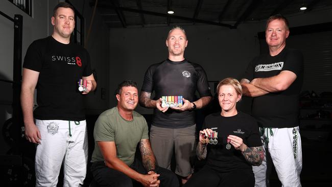 Former soldier and now physical and mental health instructor Scott Steer (centre) reflects on Remembrance Day with other members of the Veteran Grappling group, Jack Wetton, Brent Englart, Mindy Mackay and Darryl Parker at Molendinar. Picture: Jason O’Brien