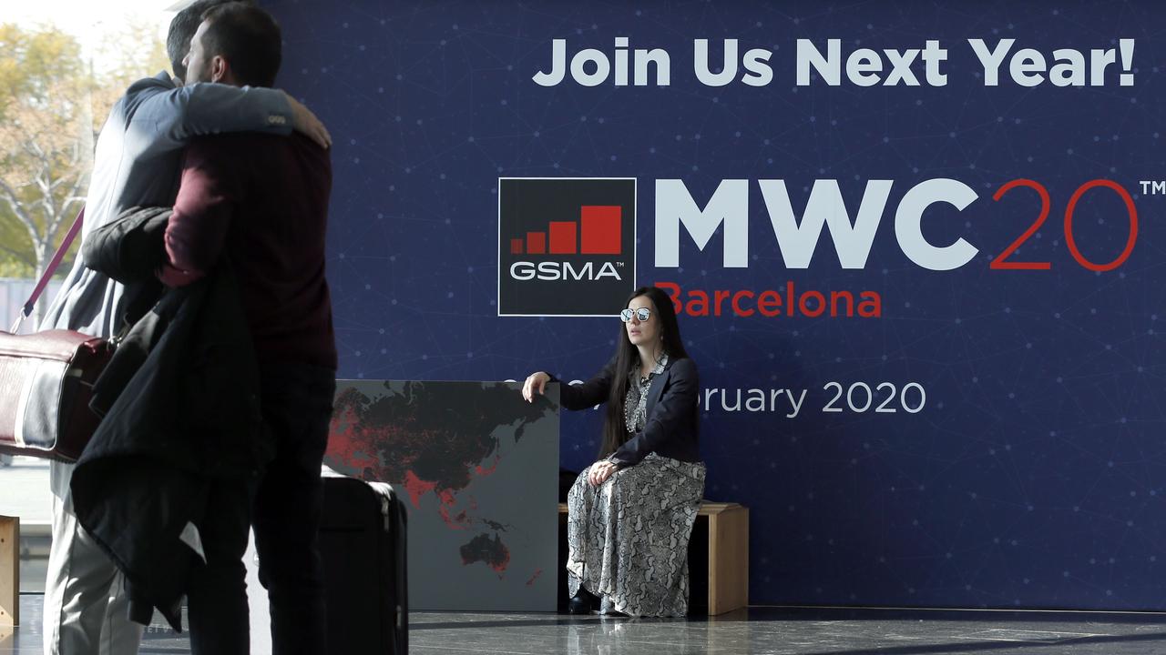 Two attendees hug on the final day of last year’s MWC. The GSMA no longer wants you to join them this year. Picture: Pau Barrena/AFP