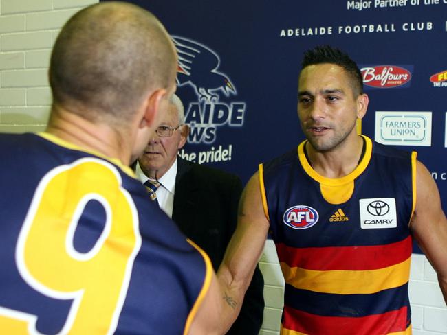 Tyson Edwards congratulates Andrew McLeod on his 313th match with the Crows.