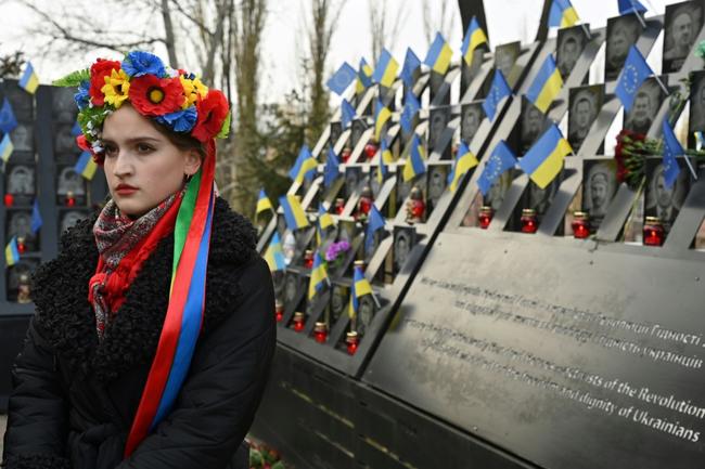 A Ukrainian woman stands next to a memorial for those killed during the Maidan protests