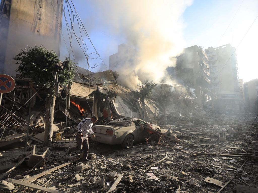 A man walks amid the rubble of a building hit in an Israeli air strike that targeted the neighbourhood of Moawwad in Beirut's southern suburbs.