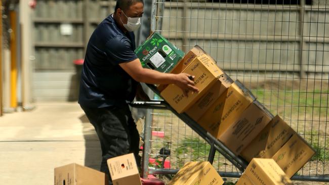 Boxes of food are removed from the building where the House of Delight restaurant is located. Picture: Stuart McEvoy