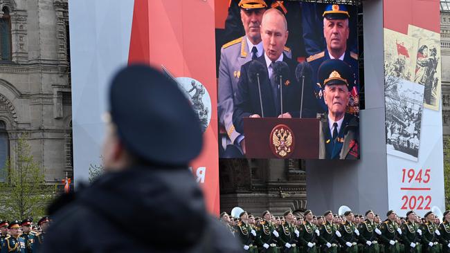 A screen shows Putin as servicemen line up on Red Square. Picture: AFO
