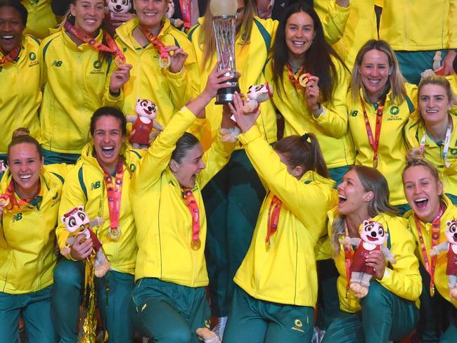Australian players hold their trophy as they celebrate winning the final of the Netball World Cup against England, in Cape Town on 06 August 2023. (Photo by RODGER BOSCH / AFP)