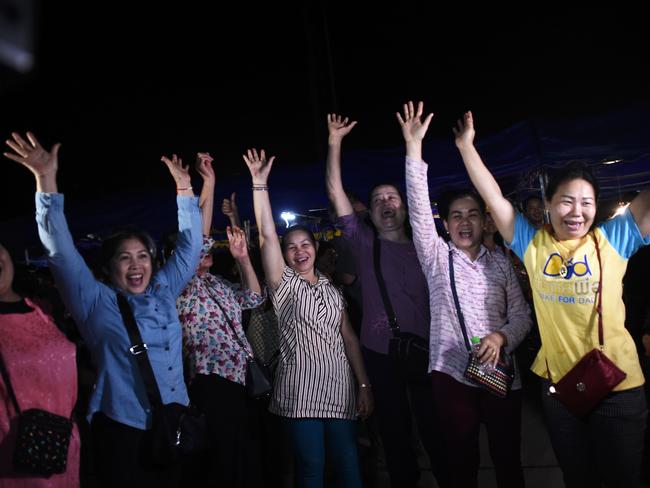 Volunteers celebrate at a makeshift press centre in the Mae Sai district of Chiang Rai province after the astonishing against-the-odds rescue mission that captivated the world. Picture: AFP Photo / Ye Aung Thu
